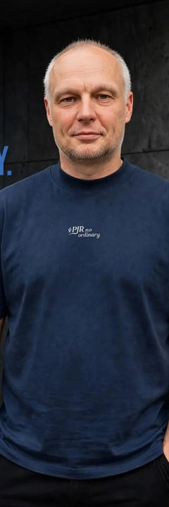 Piotr, founder PJR Built Different, wearing No Ordinary navy t-shirt